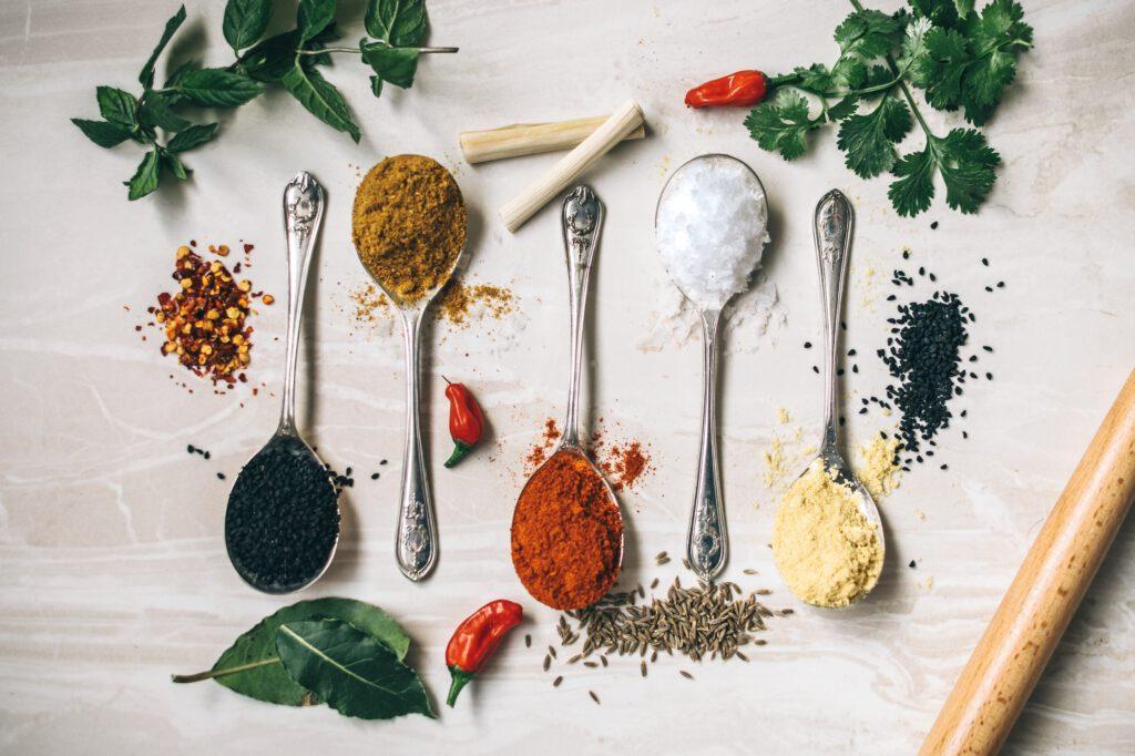 Image of five spoons, each with a different spice used in Ayurveda. The simple use of new seasonings can bring you health benefits and make your food delicious