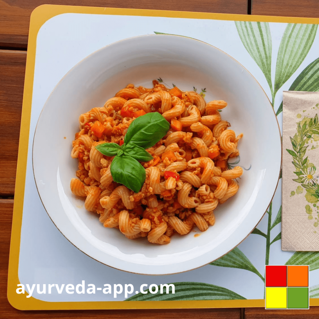 Photo of a plate of Vegan Pasta Bolognese. Beside the plate is a decorated napkin.