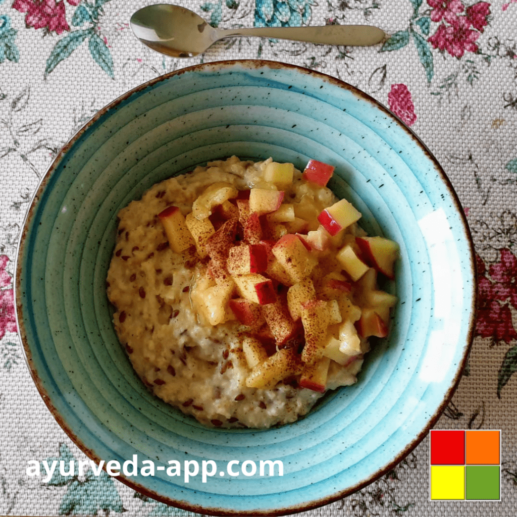 Photo of a brown-rimmed blue bowl of Sweet porridge with warm fruit topped with diced apple and ground cinnamon for garnish.