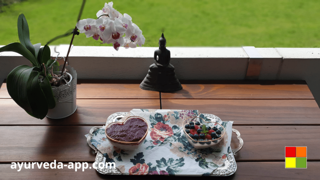 Photo of a coconut pudding with berries on a tray on the window. Ayurvedic recipes are delicious and also promote optimal health for every individual's needs.