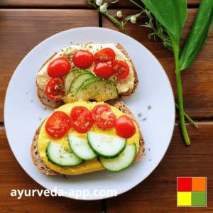 Photo of a plate with two slices of bread with Ayurvedic Curry Hummus, tomatoes, and cucumbers. The environment is decorated with leaves and flowers.