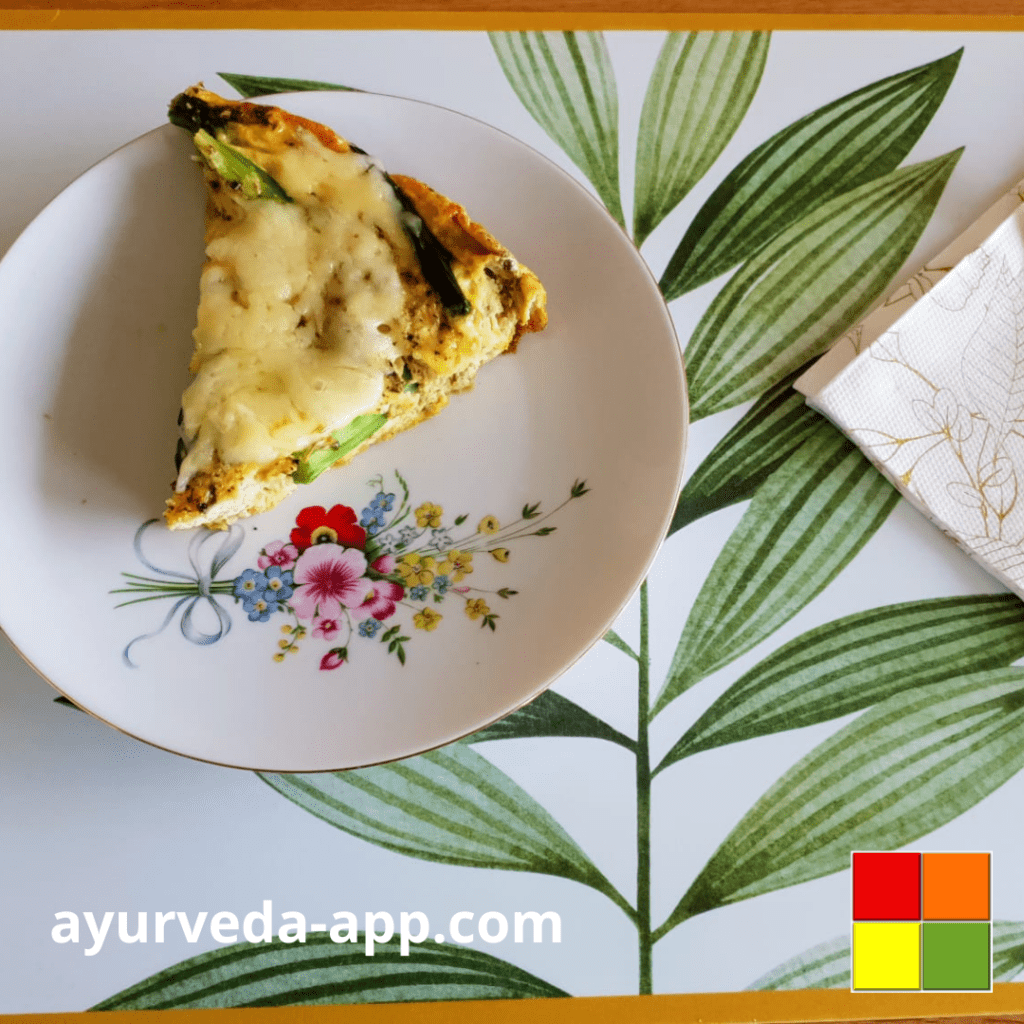 Photo of a slice of Green asparagus frittata served on a white plate decorated with flowers.