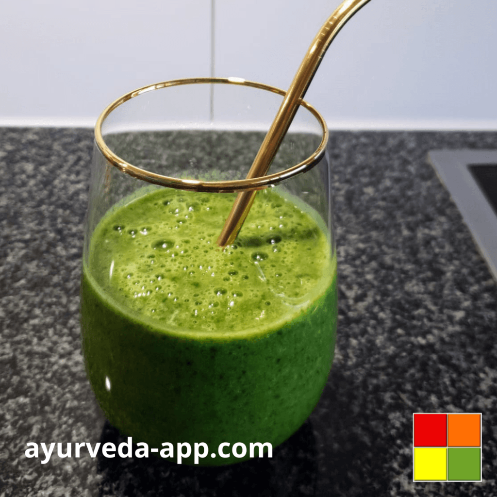 Photo of Green power smoothie served in a gold rimmed glass with a gold metal straw.