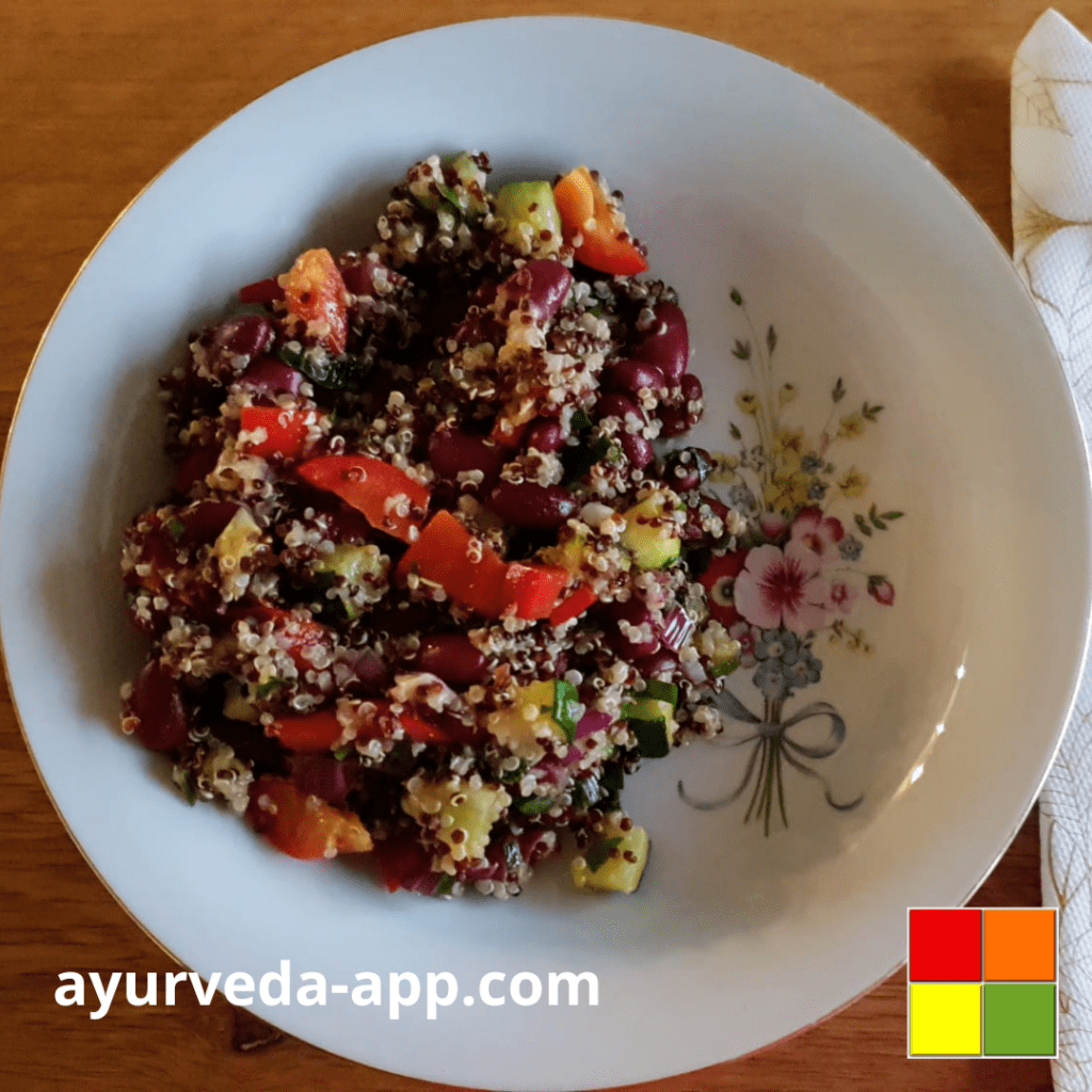 Photo of Bean salad with quinoa and zucchini served on a flowery white plate