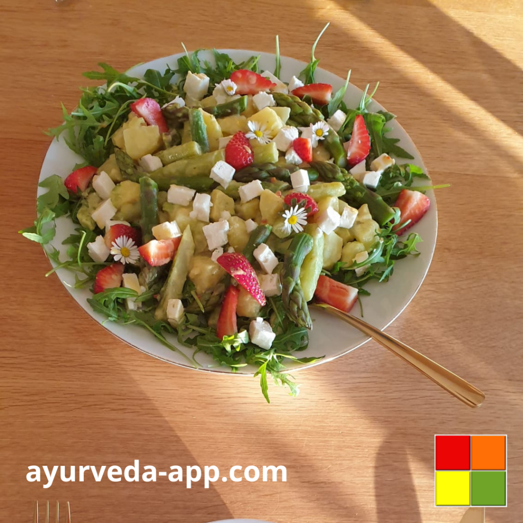 Photo of a plate of Asparagus Potato Salad, with strawberries and decorated with edible flowers.