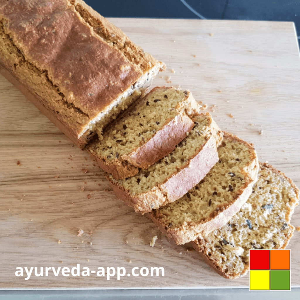 Photo of Millet-oat protein bread loaf with some slices cut on a wooden cutting board.