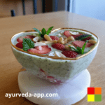 Photo of a heart-shaped bowl with Matcha chia pudding with strawberries