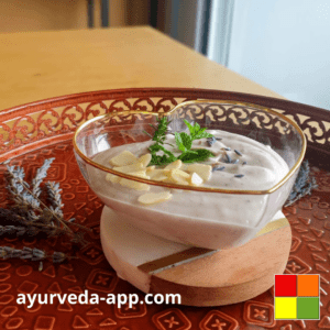 photo of a heart-shaped bowl of cashew and peach cream on top of a decorated round red tray.