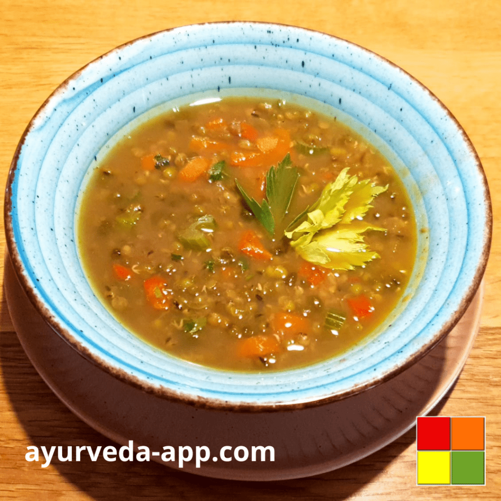 Photo of Mung Bean Soup in a blue bowl with brown edges on a wooden table.
