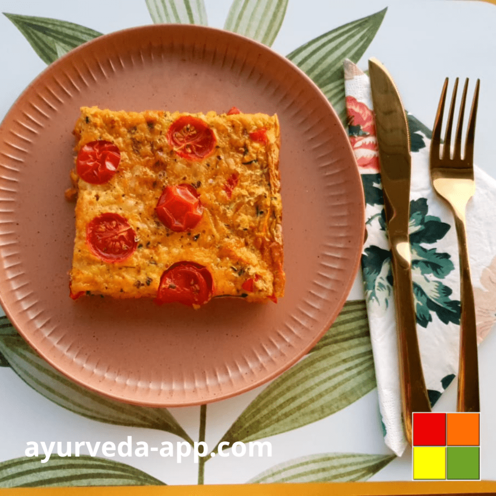 Photo of Zucchini Salty Cake on a decorated brown plate. Next to the plate are cutlery on top of a decorated napkin.