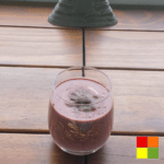 Photo of Cherry Chocolate Smoothie in a clear glass cup, decorated with golden flowers.