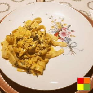 Photo of Vegan creamy tagliatelle on a white plate decorated with flowers