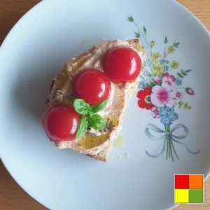 වයිට් බීන් හම්මස් ගැමි පාන් මත අතුරා, චෙරි තක්කාලි සහ නැවුම් බැසිල් වලින් ආවරණය කර, මල් පිඟානක් මත පිළිගන්වනු ලැබේ.